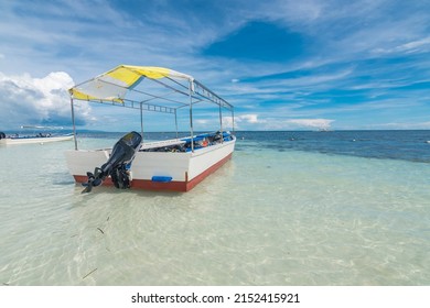 A Skiff Boat Docked In Crystal Clear Waters At Dumaluan Beach In Panglao, Bohol.