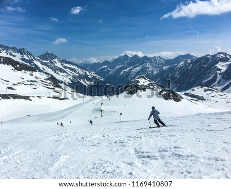 Skiier down a snowy slope