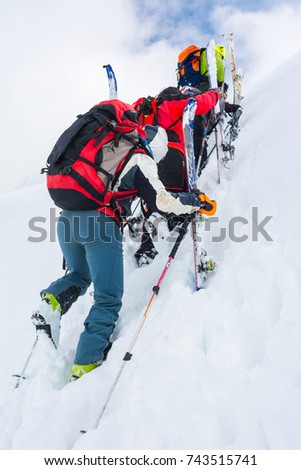 Skiiers climbing a steep slope.