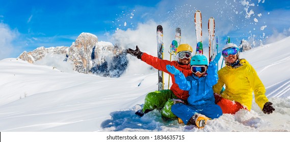 Skifahrerfamilie, die Winterurlaub auf Schnee an sonnigen kalten Tagen in den Bergen und Spaß genießt. San Martino di Castrozza, Italien.