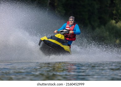 skiing on water scooter. Young man on personal watercraft in tropical lake. Active summer vacation for school child. Sport and ocean activity on beach holiday.