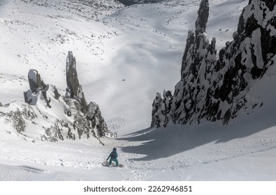 Skiing, Skier, Freeski - freeride, man snowboarding downhill Snowboarding in the snowy mountains among rocks, winter freeride extreme sport.