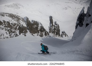 Skiing in the snowy mountains among rocks, winter freeride extreme sport. Skiing, Skier, Freeski - freeride, man snowboarding downhill