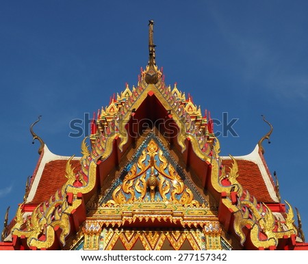 Skilfully crafted gable at Thai temple Wat Yai Sawang Arom soaring into blue sky 