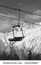 Ski-lift on ski resort and snowy mountains at sunny day. Caucasus Mountains in winter. Hatsvali, Svaneti region of Georgia. Black and white toned landscape.