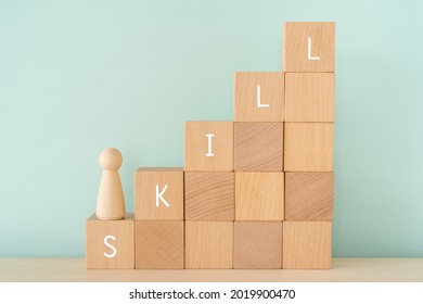 SKILL; Wooden blocks with "SKILL" text of concept and a human toy. - Shutterstock ID 2019900470