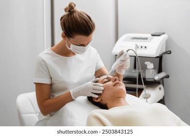 Skilled aesthetician performing facial treatment on client in modern salon - Powered by Shutterstock