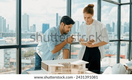 Skilled architect engineer team discussion about house model construction. Smart interior designer sharing, talking about building design while beautiful coworker taking a note. Design. Tracery