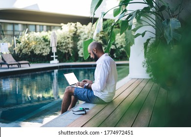 Skilled businessman using mockup laptop for making online ticketing and banking during resort recreation on Bali island, Middle Eastern digital nomad connecting to villa wifi on blank netbook - Powered by Shutterstock