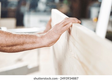 Skilled carpenter examining smooth wood plank in cozy workshop, showcasing dedication to trade with blurred background of bustling workshop - Powered by Shutterstock