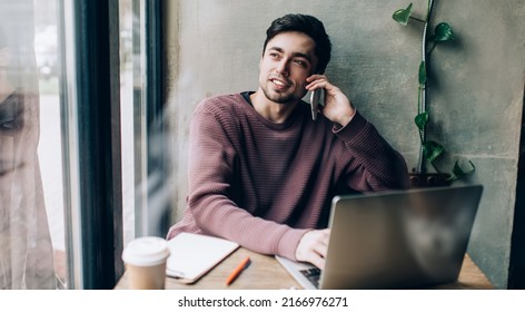 Skilled Caucasian freelancer with modern laptop computer using 4g wireless for calling and talking with partner, male programmer discussing software developing making cell consultancy conversation