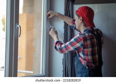 Skilled Caucasian Serviceman Weather-stripping The Home Window