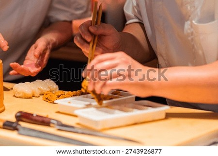 Skilled chef is preparing sushi using fresh ingredients, showcasing precision and artistry in a vibrant kitchen environment.