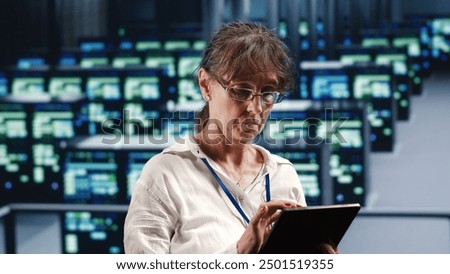 Skilled computer scientist in data center equipped to handle complex computing requirements, doing regular upgrades to server clusters, increasing processing power to prevent malfunctions
