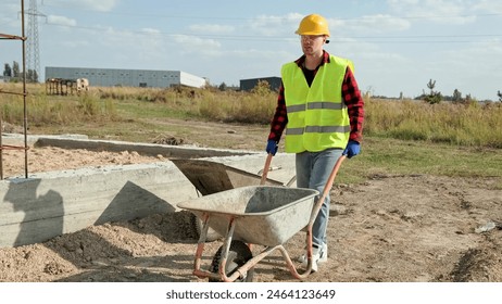 Skilled construction worker is transporting building materials on development site