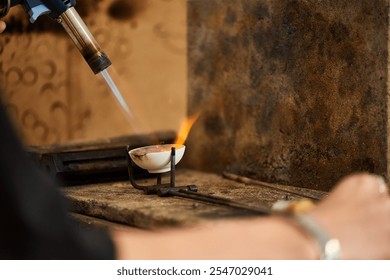 A skilled craftsman uses a torch to create stunning jewelry in an artisan workshop. - Powered by Shutterstock