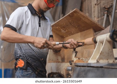Skilled craftsman using a chisel to shape a rotating wooden spindle on a lathe in a furniture workshop, with wood shavings flying. - Powered by Shutterstock - Get 15% off with code: PIKWIZARD15