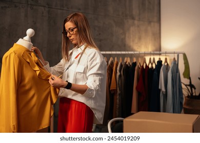 Skilled fashion designer measuring garment on dummy in workshop - Powered by Shutterstock