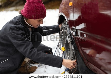 Skilled Female Driver Handles Tire Chain Installation with Ease, Conquering Icy Cold Weather Challenges on Snowy and Slippery Roads