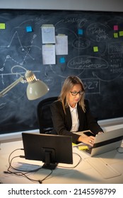 Skilled Female Financier Analyzing Financial Data. Busy Woman In Glasses Working Till Evening, Analyzing Market Data And Trading Process. Financial Analytics And Business Growth Concept