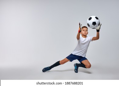 skilled goalkeeper boy get the ball in hands while defending football goal. isolated white background - Powered by Shutterstock