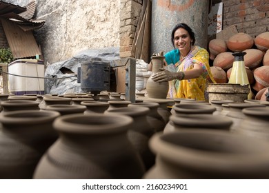 Skilled hands of a female potter shaping the clay into pot on spinning wheel - Powered by Shutterstock