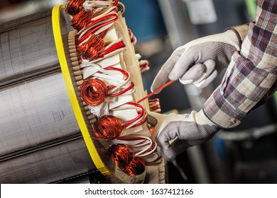 Skilled Industrial Worker Assembling A Large Electric Motor