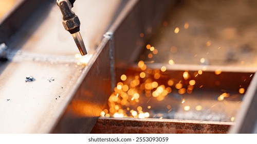 Skilled labor and craftsmanship in metal fabrication. Use of torches for cutting metal. Safety measures and personal protective equipment for metalworkers. Precision and accuracy in metal cutting. - Powered by Shutterstock