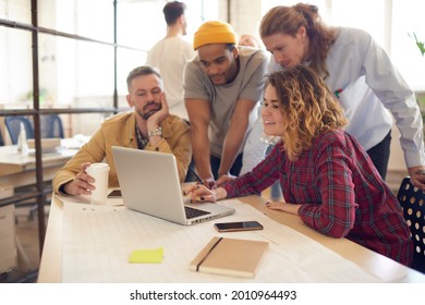 Skilled Male And Female Architects With Blueprint Creating Design Project Togetherness During Brainstorming Meeting In Coworking, Colleagues Browsing Web Page On Netbook Technology Using 4g Wireless