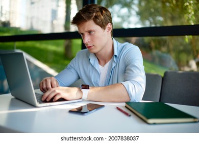 Skilled Male Programmer Updating Software Settings On Modern Netbook Technology Using 4g Internet Indoors, Caucasian Student E Learning On Laptop Computer Connecting To Wireless For Online Browsing