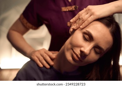 Skilled masseuse stretching female client neck during Thai massage session - Powered by Shutterstock