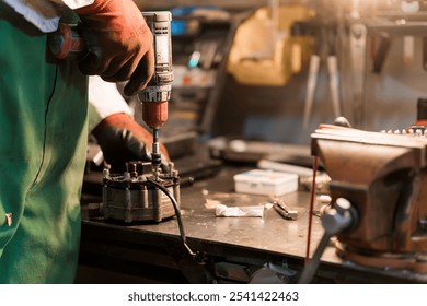 Skilled Mechanic Using Power Drill in Workshop for Equipment Repair.