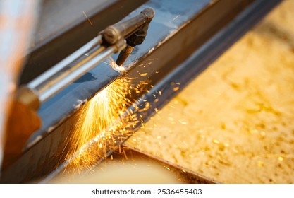 Skilled metalworker uses torch to cut through steel. Sparks fly as craftsman demonstrates precision in industrial workshop. Concept of balancing risk and expertise in dangerous metalworking processes. - Powered by Shutterstock