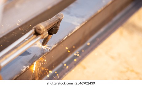 Skilled metalworker uses torch to cut through steel. Sparks fly as craftsman demonstrates precision in industrial workshop. Concept of balancing risk and expertise in dangerous metalworking processes. - Powered by Shutterstock