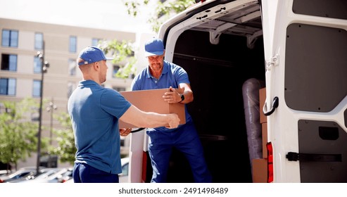 Skilled Movers Delivering Boxes to a Moving Truck: Teamwork, Professionalism, and Efficiency in Action by Diverse Group of Workers.