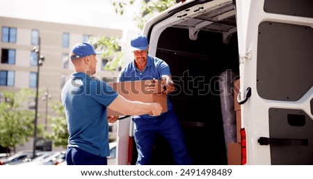 Skilled Movers Delivering Boxes to a Moving Truck: Teamwork, Professionalism, and Efficiency in Action by Diverse Group of Workers.