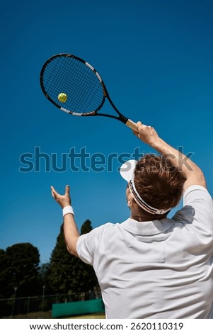 A skilled player in white serves under a clear blue sky, embodying summer tennis.
