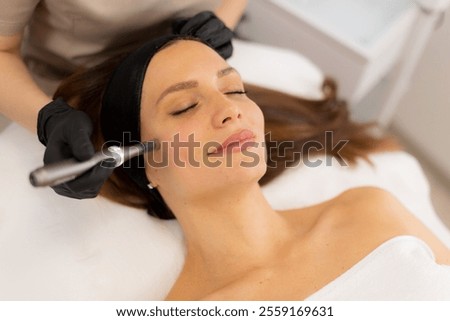A skilled practitioner performs microneedling on a relaxed client, enhancing skin texture and rejuvenation. The tranquil spa ambiance promotes a sense of calm and well-being.