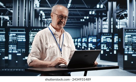 Skilled IT professional expertly managing data while navigating in industrial server room. Expert ensuring flawless cybersecurity protection, optimizing systems and performing necessary updates - Powered by Shutterstock