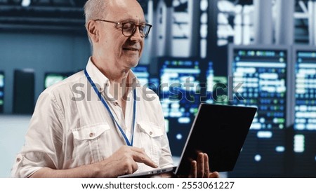 Skilled IT professional navigating network of supercomputers in industrial server farm. Specialist with laptop ensuring errorless operations, doing optimizations and maintenance in data center