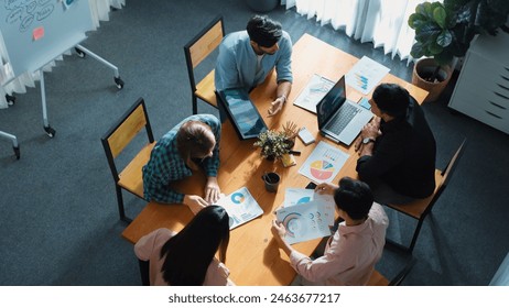 Skilled project manager walking at table while colleague brainstorm idea. Business team working together to plan marketing strategy while looking at data analysis or financial statistic. Convocation. - Powered by Shutterstock