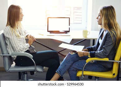 Skilled Recruiter Making Job Interview With Female Student For IT Occupation,reading Paper Cv While Sitting In Modern Office With Free Internet Access And Laptop Computer With Blank Mock Up Screen