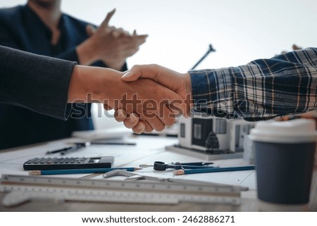 Skilled team of engineers collaborates in meetings, drafting blueprints for condos, apartments, and houses. Negotiating costs, bids, and contracts, they ensure efficient cooperation on construction