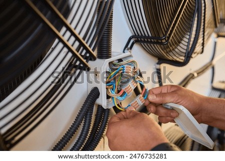 A skilled technician is efficiently fixing electrical wiring in a junction box using the right tools