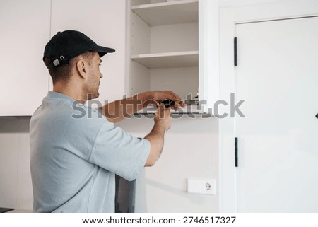 Skilled Technician Performing Precise Interior Cabinet Modifications Under Workshop Lighting