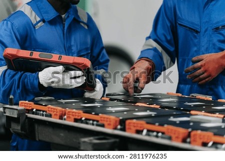 Skilled technicians are seen diagnosing and disassembling lithium-ion car batteries in an auto service workshop, focusing on maintenance and safety protocols.