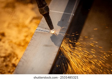 Skilled welder cuts metal with a gas torch in industrial workshop. Sparks fly during precision fabrication process. Craftsman control and expertise in metalworking. Gas torch cuts through steel. - Powered by Shutterstock