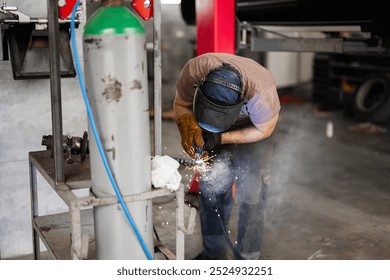 A skilled welder wearing protective gear concentrates on metalwork in a busy industrial workshop. Sparks fly as the welding process creates a vibrant display of craftsmanship and industry. - Powered by Shutterstock