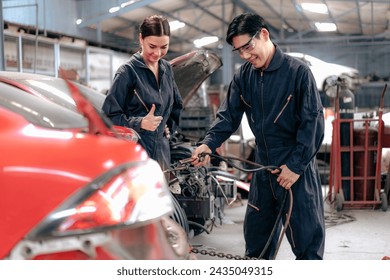 Skilled welder welding damage auto body car with blue spark at workshop. Auto mechanic in uniform working at repair garage station fixing broken vehicle. Repairman occupation in automotive maintenance - Powered by Shutterstock