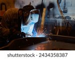 Skilled Welder at Work in Industrial Workshop, Sparks Flying